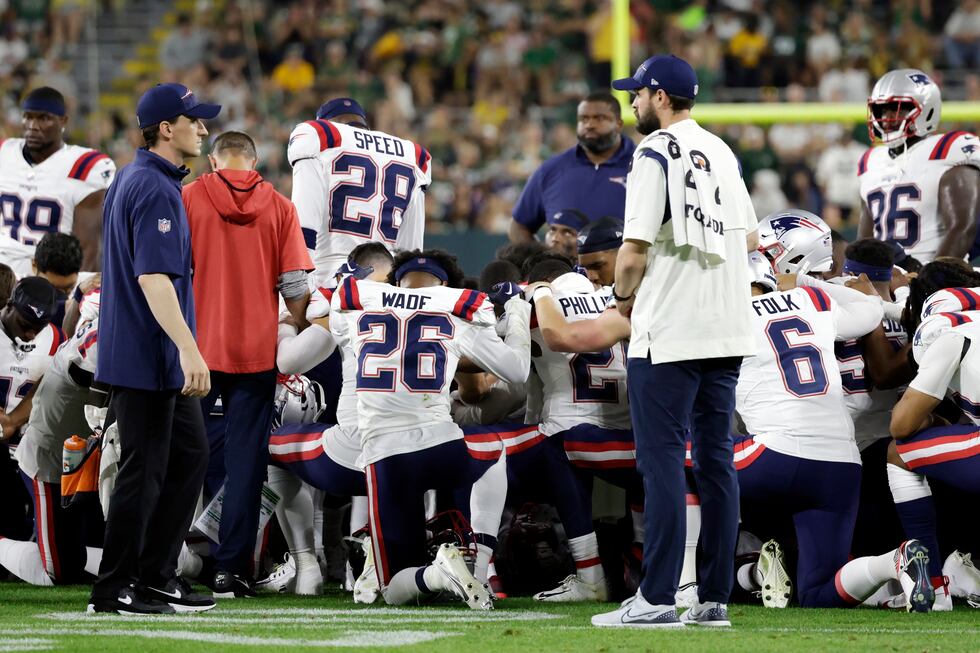 New England Patriots players kneel after cornerback Isaiah Bolden was injured during the...