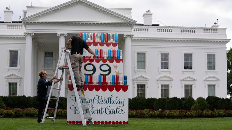Workers work on a wooden cake display on the North Lawn of the White House, Saturday, Sept....