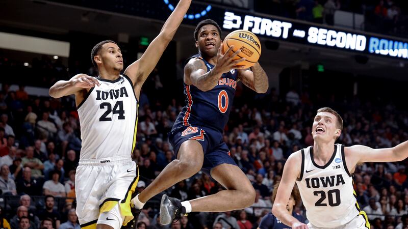 Auburn guard K.D. Johnson (0) shoots around Iowa forward Kris Murray (24) during the first...
