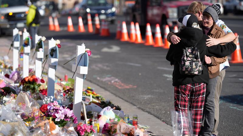 Visitors hug at a makeshift memorial near the scene of a mass shooting at a gay nightclub...